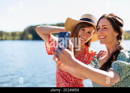 Lächelnde Freundinnen, die Selfie machen Stockfoto