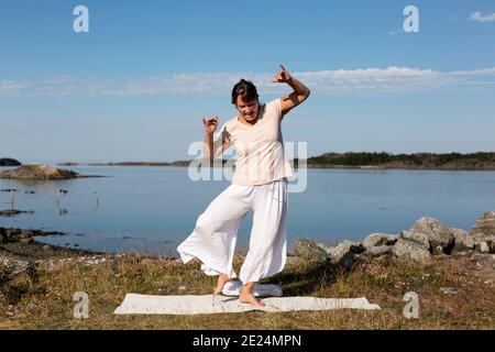 Frau Yoga am Meer Stockfoto