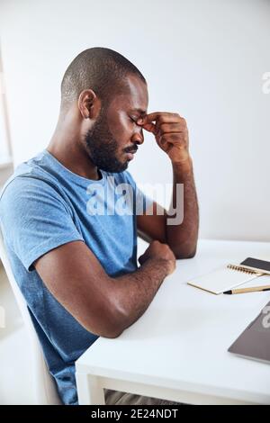 Wirtschaftsspezialist, der seine Augen aus Schlafmangel berührt Stockfoto