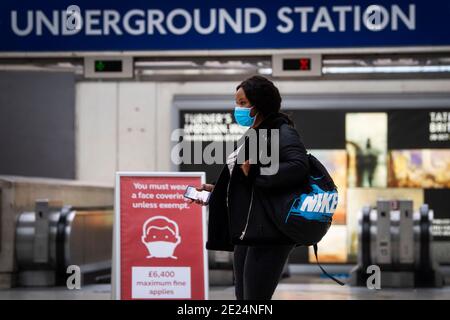 Ein Pendler mit Gesichtsbedeckung auf der Bahnhofsstation in Waterloo während der morgendlichen Hauptverkehrszeit in London, während Englands dritte nationale Sperre zur Eindämmung der Ausbreitung des Coronavirus weiter andauert. Stockfoto