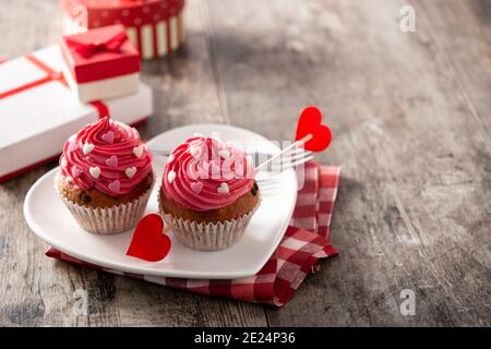 Cupcakes verziert mit Zuckerherzen zum Valentinstag auf Holz Tabelle Stockfoto