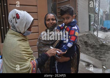 Pakistanischer Gesundheitsarbeiter verabreicht einem Kind einen Polio-Impfstoff Während einer Tür-zu-Tür-Kampagne zur Polio-Impfung in Lahore Stockfoto