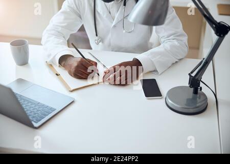 Hände eines Arztes, der einen Bleistift hält Stockfoto