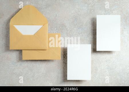 Hochzeitsbriefpapier Vorlage. Draufsicht Kraftpapier-Umschläge und leere Papierkarte auf Stein-Tischplatte. Minimalistischer Stil. Flach liegend. Stockfoto