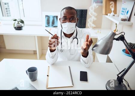 Medizinische Fachkraft in einer Gesichtsmaske Begrüßung des Kunden Stockfoto