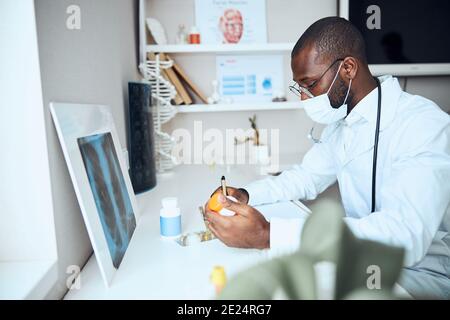 Medic schreibt die Pillen-Anweisungen auf ein Papierblatt um Stockfoto