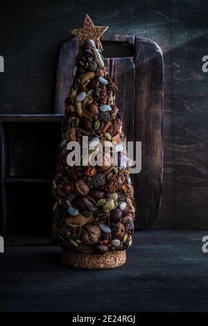 Rustikales Christbaumschmuck aus frischen Nüssen und Gewürzen Stockfoto