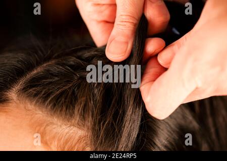 Frau Hände Flechten Brünette Mädchen lange Haare. Nahaufnahme Stockfoto