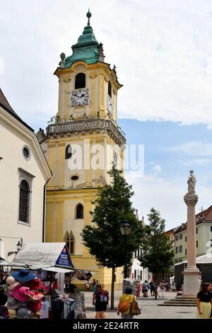 Bratislava, Slowakei - 21. Juli 2019: Nicht identifizierte Menschen auf dem Straßenmarkt mit zugänglicher Turm des alten Rathauses und Maria-Säule Stockfoto