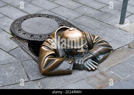 Bratislava, Slowakei - 21. Juli 2019: Lustige Bronzeskulptur mit dem Namen man at Work zeigt einen Mann in einem Schachtloch in der Fußgängerzone der Altstadt Stockfoto