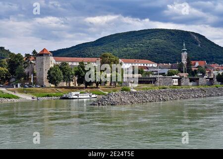 Hainburg, Österreich - 21. Juli 2019: Nicht identifizierte Menschen am Ufer der Donau mit mittelalterlichem Turm und Burg auf einem Hügel Stockfoto