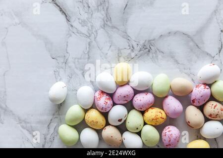 Frohes Osterkonzept. Vorbereitung für den Urlaub. Osterpastell Süßigkeiten Schokoladeneier Süßigkeiten auf trendigen grauen Marmor-Hintergrund. Einfache Minimalismus-Wohnung Stockfoto