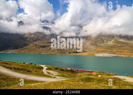Landschaft am Bernina Pass mit dem Weißen See und dem roten Bernina Express Zug zwischen Italien und der Schweiz im Sommer. Stockfoto