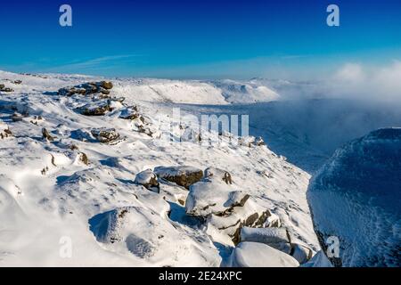 Winterschnee am südlichen Rand des Kinder Scout in Der Peak District National Park, UK von den Woolpacks aus gesehen Stockfoto