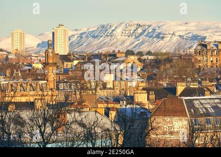 Verschneite Stadtansicht des westlichen Endes von glasgow an einem schönen Wintertag. Aus dem Kelvingrove Park in Richtung Campsie Fells. Stockfoto
