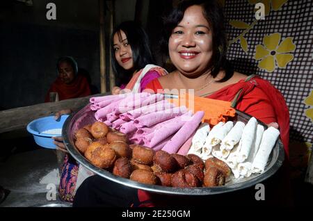 Nagaon, Assam, Indien - 12. Januar 2021: Eine Frau zeigt die zubereiteten traditionellen pithas (Reiskuchen und -Brötchen) für Magh Bihu im Kachamari Dorf im Nagaon Bezirk von Assam, Indien. Kredit: DIGANTA Talukdar / Alamy Live Nachrichten Stockfoto