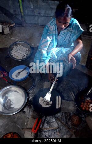 Nagaon, Assam, Indien - 12. Januar 2021: Eine Dame bereitet traditionelle Teelpithas für Magh Bihu im Kachamari Dorf im Nagaon Bezirk von Assam, Indien, vor. Besonders Magh Bihu ist eine Feier der Fülle der Ernte der Natur und eine Ode an die Kontinuität der Existenz. Es ist nur natürlich, dass Magh Bihu oder Bhogali Bihu, wie es allgemein genannt wird, eine reiche Feier des reichen Stausees des Staates mit traditionellen Speisen und Delikatessen Zubereitungen ist. Kredit: DIGANTA TALUKDAR/Alamy Live Nachrichten Stockfoto