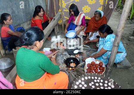 Nagaon, Assam, Indien - 12. Januar 2021:Dorffrauen sind damit beschäftigt, traditionelle Teelpithas und andere Gegenstände für Magh Bihu im Kachamari Dorf im Nagaon Bezirk von Assam, Indien, vorzubereiten. Besonders Magh Bihu ist eine Feier der Fülle der Ernte der Natur und eine Ode an die Kontinuität der Existenz. Es ist nur natürlich, dass Magh Bihu oder Bhogali Bihu, wie es gemeinhin genannt wird, eine reiche Feier des reichen Stausees des Staates mit traditionellen Speisen und Delikatessen Zubereitungen ist. Kredit: DIGANTA TALUKDAR/Alamy Live Nachrichten Stockfoto