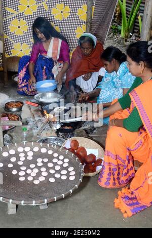 Nagaon, Assam, Indien - 12. Januar 2021:Dorffrauen sind damit beschäftigt, traditionelle Teelpithas und andere Gegenstände für Magh Bihu im Kachamari Dorf im Nagaon Bezirk von Assam, Indien, vorzubereiten. Besonders Magh Bihu ist eine Feier der Fülle der Ernte der Natur und eine Ode an die Kontinuität der Existenz. Es ist nur natürlich, dass Magh Bihu oder Bhogali Bihu, wie es allgemein genannt wird, eine reiche Feier des reichen Stausees des Staates mit traditionellen Speisen und Delikatessen Zubereitungen ist. Kredit: DIGANTA TALUKDAR/Alamy Live Nachrichten Stockfoto