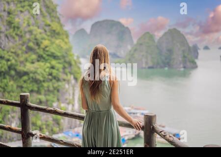 Attraktive Frau in einem Kleid reist in Halong Bay. Vietnam. Reisen nach Asien, Glücksgefühle, Sommerferienkonzept. Malerische Meereslandschaft Stockfoto