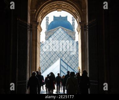 Paris, Frankreich. Touristen gehen durch die Passage in Richtung Pyramide des Louvre Museum. Stockfoto