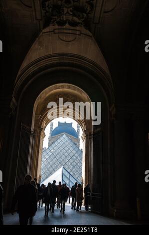 Paris, Frankreich. Touristen gehen durch die Passage in Richtung Pyramide des Louvre Museum. Stockfoto