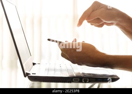 Nahaufehende Geschäftsleute nutzen im Büro Smartphones und Laptops. Stockfoto