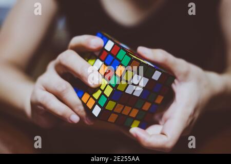 BANGA, PH– 30. MAI 2019: Der Rubik-Würfel wurde 1974 vom ungarischen Bildhauer und Architekturprofessor Erno Rubik erfunden. Junge Dame Hände auf Würfel. Stockfoto