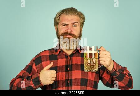 lagerbier. Entspannter, gutaussehender Mann, der leckeres Bier trinkt. Glas im Pub genießen. Frisches, kaltes Lagerbier vorwegnehmen. Nach einem anstrengenden Arbeitstag. Bier vom Fass an der Bar im Pub trinken. Stockfoto