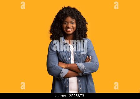 Selbstbewusst schöne schwarze Frau auf gelbem Hintergrund Stockfoto