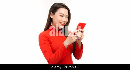 Junge Frau in vietnamesischen traditionellen Dressing zeigen Smartphone in Ihre Hand Stockfoto