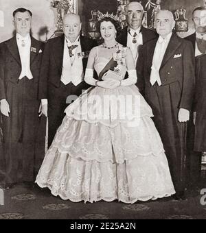 EDITORIAL NUR Queen Elizabeth II unterhält die Premierminister des Commonwealth im Buckingham Palace im Jahr 1952. Von links nach rechts, Mr. S.G. Holland (Neuseeland), Winston Chuchill (Großbritannien), Robert Menzies (Australien) und St. Laurent (Kanada). Aus dem Königin-Elisabeth-Krönungsbuch, veröffentlicht 1953. Stockfoto