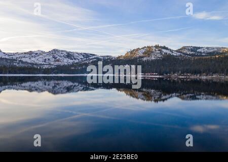 DONNER LAKE, CALIFORNIA, USA - 02. Jan 2021: Schneebedeckte Berge in der Sierra Nevada spiegeln sich auf der Oberfläche des Donner Lake. Stockfoto