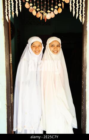 Phang Nga, Thailand - 30. JANUAR 2016: Portrait zwei charmante muslimische Teenager-Mädchen in traditioneller Kleidung stehen vor der Tür. Phang Nga. Stockfoto