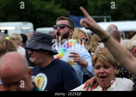 PKD Festival Dalgety Bay ,Fife Scotland, UK 23. Juli 2016. Das PKD Festival ist ein Benefizfestival für Musik und Fahrräder. Ein Familienfestival, das eine Kinderzone und ein Festplatz umfasst, auf dem Kinder unter 16 Jahren mit einem Erwachsenen kostenlos sind. PKD ist heute als eines der führenden Charity-Festivals und Motorradshows in Schottland bekannt. Mann müde bunte Girlande in der Menge Stockfoto