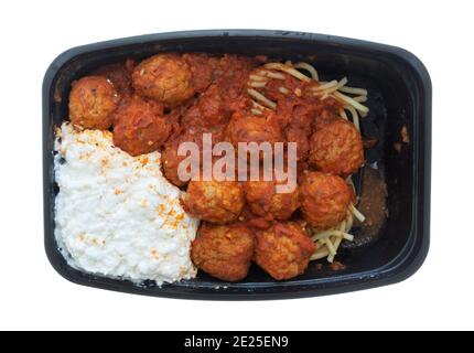 Draufsicht auf Spaghetti und Fleischbällchen mit Hüttenkäse in einem schwarzen Tablett isoliert auf weißem Hintergrund. Stockfoto