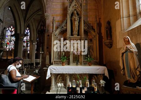 Ste Madeleine (Magdalene) Kirche, Verneuil-sur-Avre, Frankreich. Frau, die eine Gebetsabsicht schreibt. Stockfoto