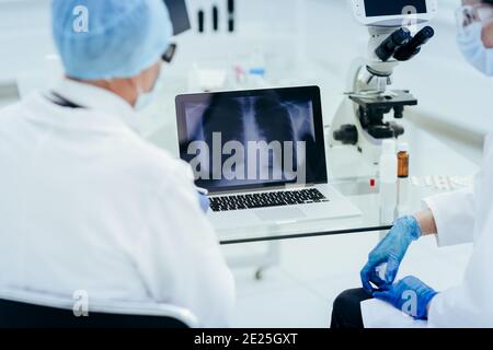 Ärzte Blick auf die Thorax-Röntgenscan auf dem Bildschirm des Laptops . Stockfoto