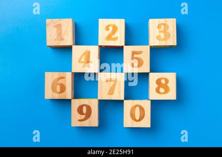 Zahlen. Bunte Holz-Alphabet-Blöcke auf blauem Hintergrund, flacher Lay, Draufsicht. Stockfoto