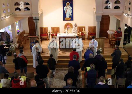 Katholische Kirche während covid-19 Epidemie. Sonntagsmesse. Priester, die die heilige Kommunion geben. Heiligtum von La Benite Fontaine. Stockfoto