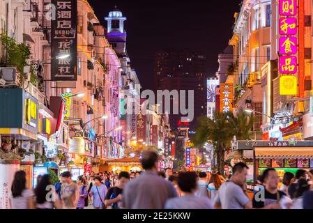 XIAMEN, CHINA - 11. JUNI 2014: Fußgänger gehen nachts auf der Zhongshan Straße. Die Straße ist die wichtigste Handelsstraße in Xiamen und Teile wurden vollständig Stockfoto