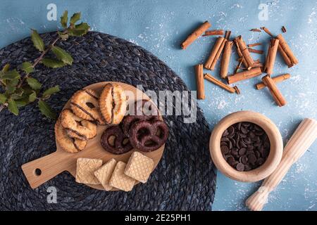 Draufsicht von verschiedenen Keksen auf einer Holzplatte mit Zimtrollen Stockfoto