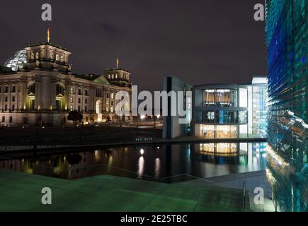 Berlin, Deutschland. Januar 2021. Die Lichter der Straßenbeleuchtung am Reichstagsufer, am Reichstag und am Paul-Löbe-Haus (r) spiegeln sich abends an der Wasseroberfläche der Spree. Quelle: Soeren Stache/dpa-Zentralbild/ZB/dpa/Alamy Live News Stockfoto