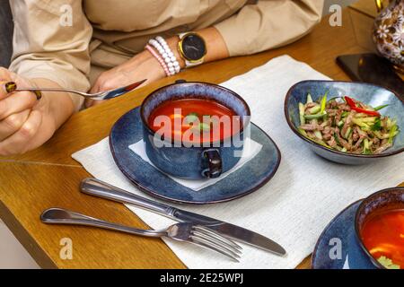 Ein Fragment der Tischeinstellung in einem Restaurant oder Café. Salat, erster und zweiter Gang. Das Konzept des Business Lunch. Stockfoto
