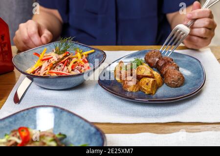 Ein Fragment der Tischeinstellung in einem Restaurant oder Café. Salat, erster und zweiter Gang. Das Konzept des Business Lunch. Stockfoto