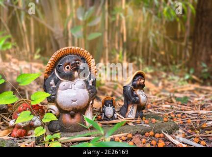 tokio, japan - november 05 2020: Nahaufnahme einer Gruppe japanischer shigaraki-Keramik, die eine tanuki-Rakoon-Hundefamilie zeigt, die im Bambuswald steht Stockfoto