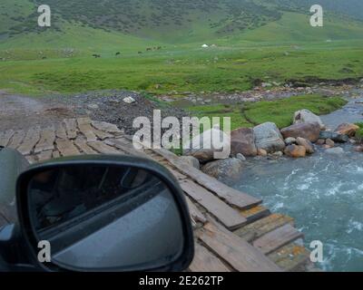 Überqueren eines Flusses auf einer provisorischen Brücke. Nationalpark Besch Tasch in der Talas Alatoo Bergkette, Tien Shan oder Heavenly Mountains. Asien, Zentral-A Stockfoto