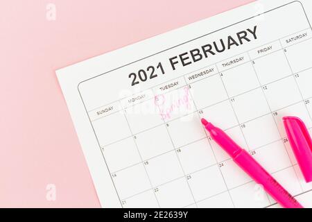 Groundhog Day Konzept. Das Wort Frühling steht auf dem Kalender am 02. Februar. Rosa Hintergrund. Flach liegend. Stockfoto