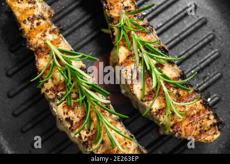 Geröstetes Lachsfischfilet mit Rosmarin auf einem Grillstift. Hausgemachtes gesundes Abendessen Stockfoto