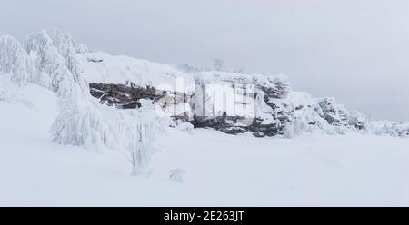 Bergrücken von schneebedeckten Felsen in einer düsteren Winter verlassenen Landschaft Stockfoto